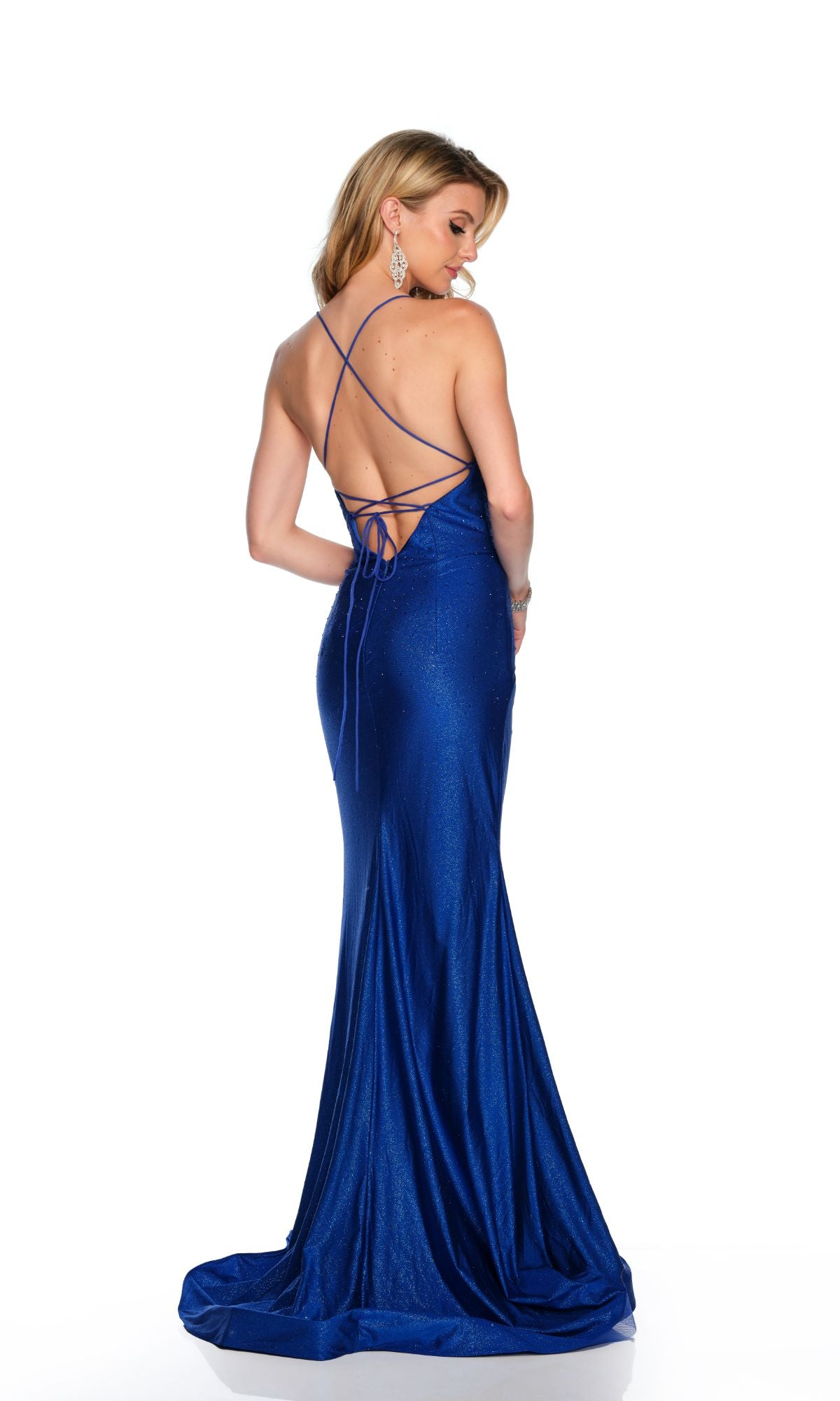 A woman models the Long Formal Dress 11642 by Dave and Johnny, featuring a royal blue color, open back, and thin crisscross straps, as she stands looking over her left shoulder against a plain white background.
